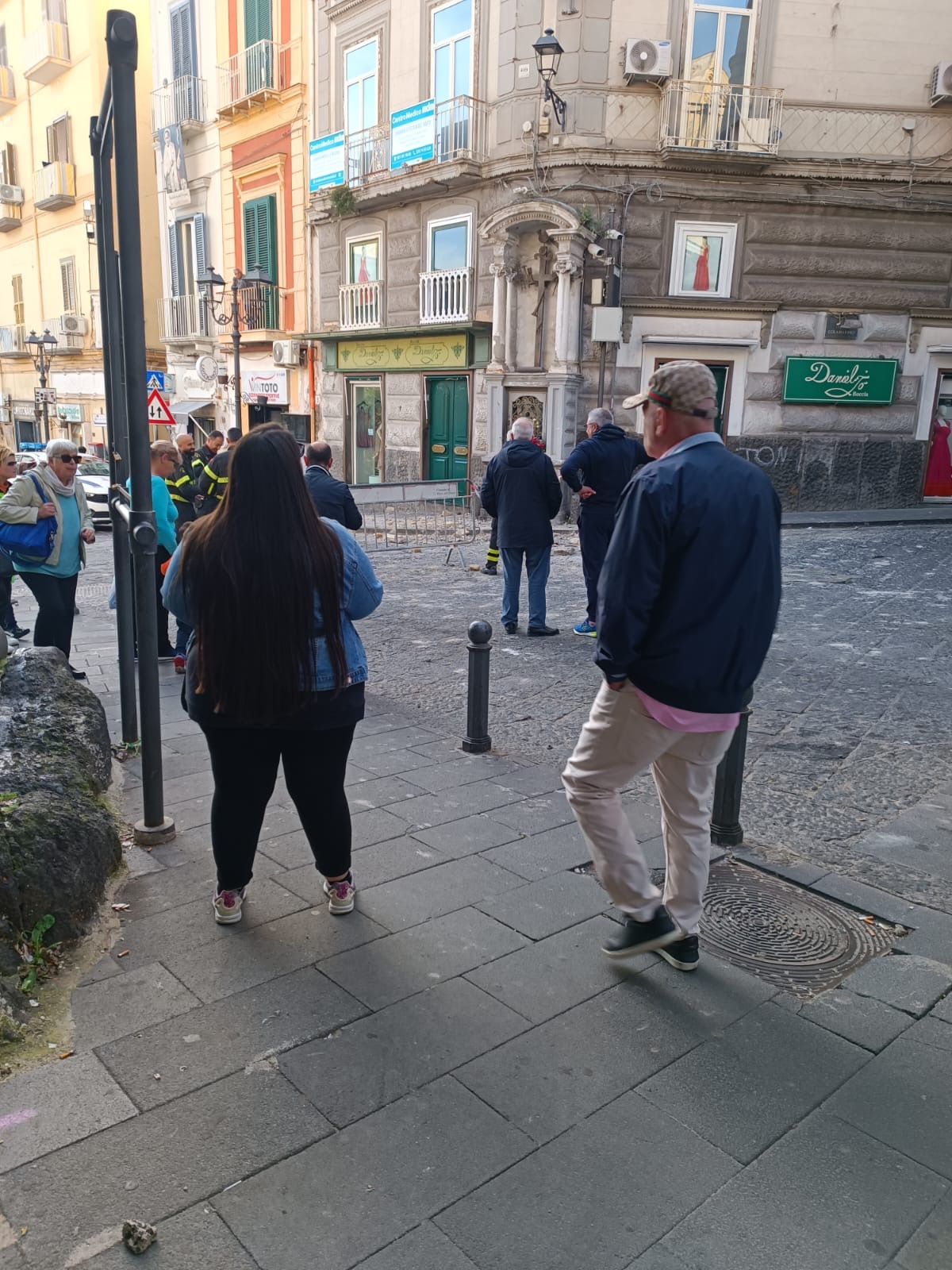 Lo sguardo dei passanti, preoccupati dopo il crollo di un cornicione.